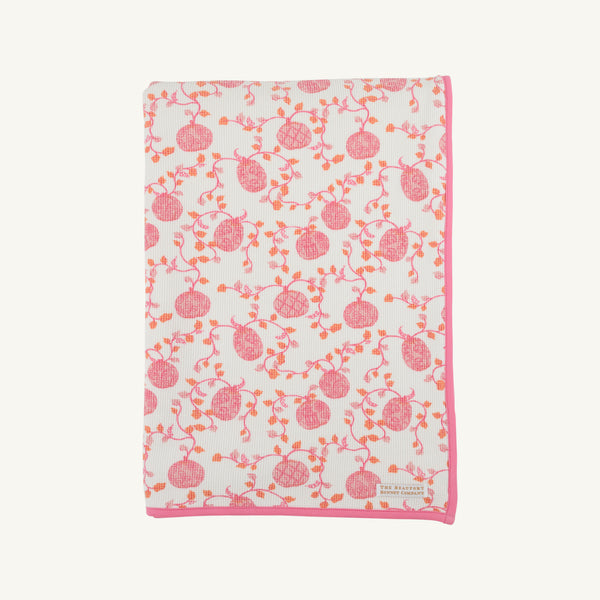 The Silent Night Throw - Gourd-geous (Palmetto Pearl) with Romany Rose by The Beaufort Bonnet Company features a cozy white design with a pink border, adorned with charming pink and orange pomegranates and vines, reminiscent of the comforting warmth of a waffle knit throw.