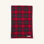 A folded Silent Night Throw - Society Prep Plaid blanket in a red, green, and white plaid pattern with a solid red border.