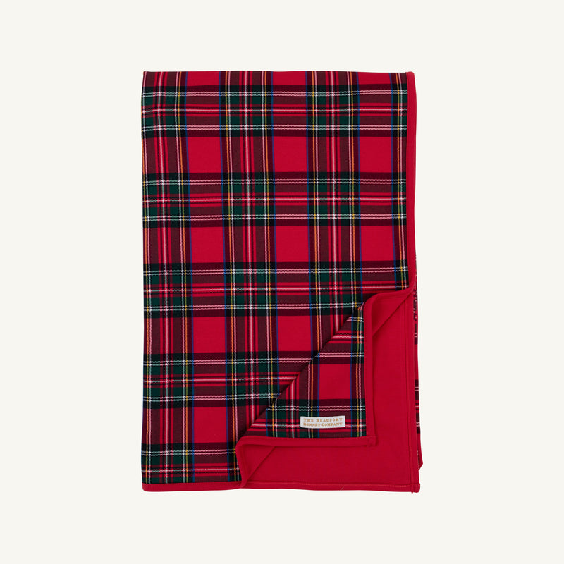 A folded Silent Night Throw - Society Prep Plaid blanket in a red, green, and navy plaid pattern with a solid red backing.