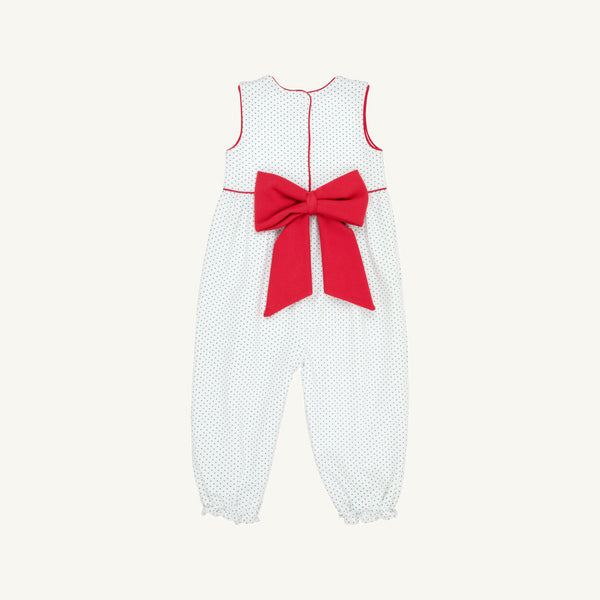 The Sleeveless Rebecca Romper - Kiawah Kelly Green Microdot with Richmond Red by The Beaufort Bonnet Company features a charming green microdot pattern, bright red piping, and a large red bow at the back. Made from soft Pima cotton, this delightful children’s jumpsuit is pictured on a plain light background—perfect as a holiday outfit.